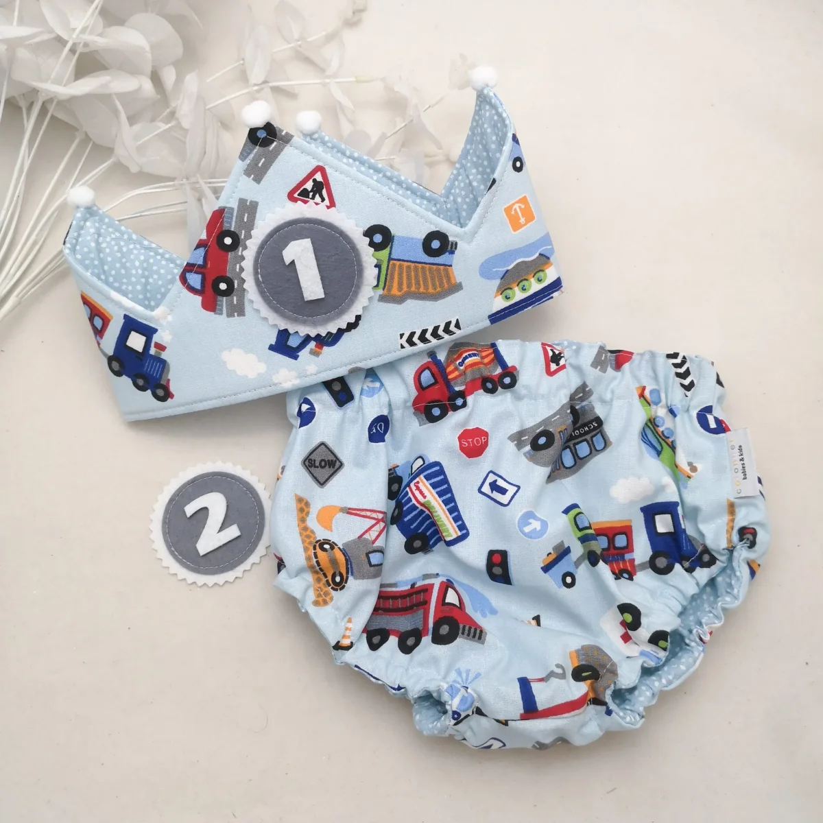 Conjunto corona cumpleaños y cubrepañal reversible vehículos celeste